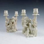 A pair of German porcelain candelabras, modelled as seated figures with goats, the candlesticks