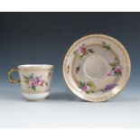 A Sevres porcelain cup and saucer, decorated with flowers to a gilt lace ground, marked with an N