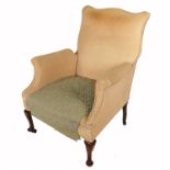 An upholstered armchair, raised on short cabriole legs, together with another high back wing