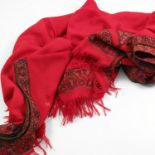 Three ladies' shawls, a red ground shawl with paisley decoration, an elaborate stitched shawl