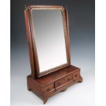 An 18th century design walnut swing frame toilet mirror, having three frieze drawers, raised on