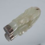A carved jade brooch, with white metal unmarked mount, 6.6cm long