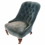 A late Victorian deep button back easy chair, raised on front turned legs