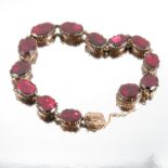 A garnet bracelet, the thirteen oval flat cut stones in closed back settings, 15.7g grossCondition