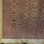 An Eastern rug, decorated with repeating symbols in brown, red, orange and white, 70ins x 50ins