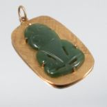 A nephrite jade Tiki pendant, the carving set to a rectangular textured panel, stamped '9ct', 3.