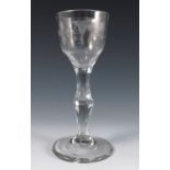 A late 18th century drinking glass, with etched decoration to the bowl and a faceted stem, height