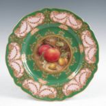 A Royal Worcester plate, decorated with a central fruit panel of two plums, gooseberries and