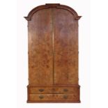 A continental style walnut armoire, having dome top, over quarter veneered doors revealing hanging