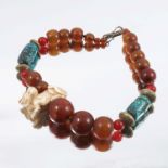 An ethnic style bead necklace with simulated turquoise, simulated amber and a composition netsuke