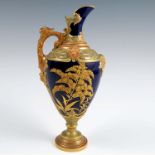 A Royal Worcester ewer, decorated with gilt flowers to a dark blue ground with moulded gilding to