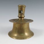 An Antique brass Heemskerk candlestick, with pierced stem, above a dished drip tray on a spreading