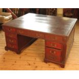 An Edwardian mahogany pedestal partners desk, fitted with nine drawers around both sides of the