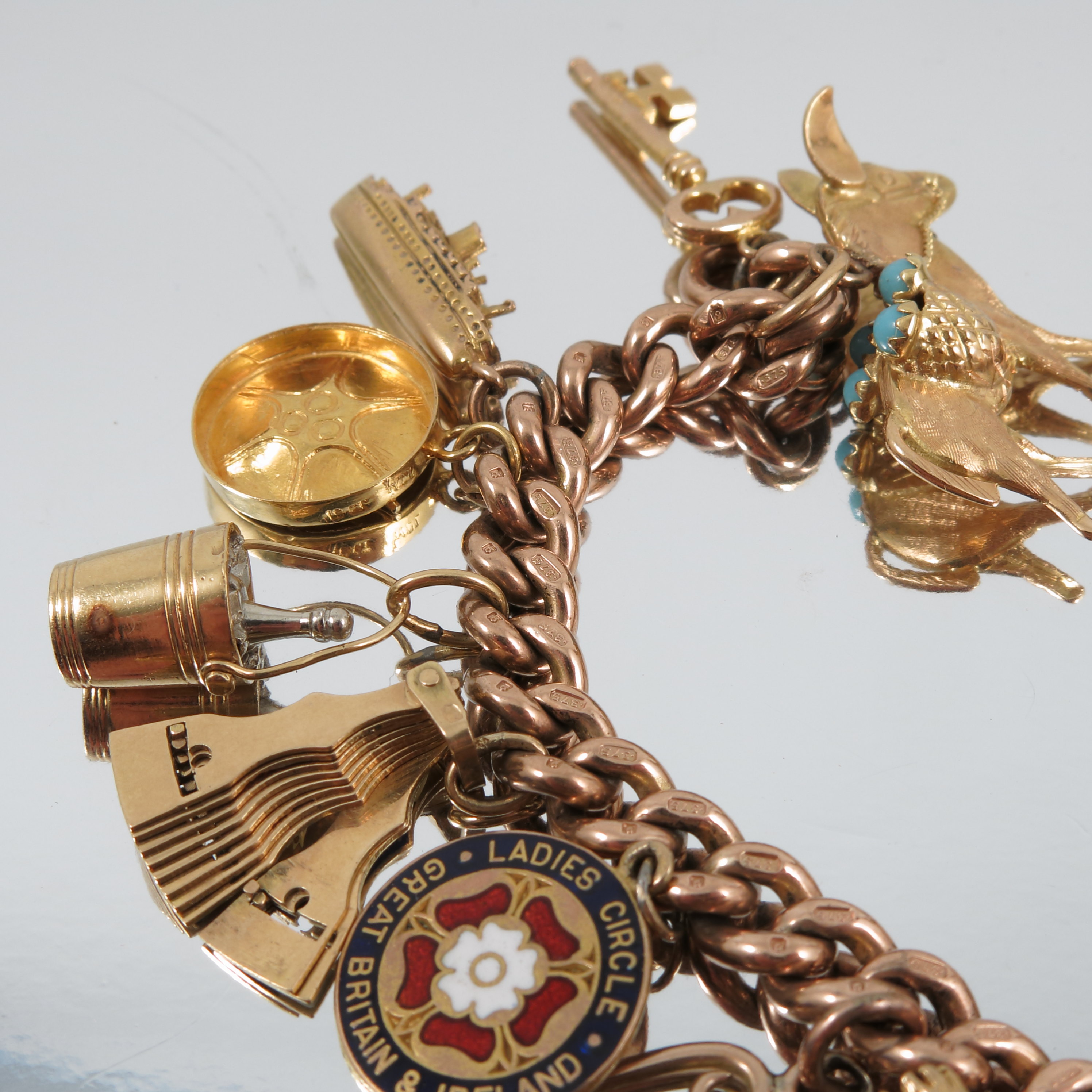 A 9 carat gold bracelet, of solid curb links, with sixteen charms attached including a Spade Guinea, - Image 3 of 4