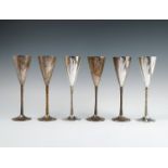 A set of silver champagne flutes, by Stuart Devlin, with gilt bark effect stems, London, numbered