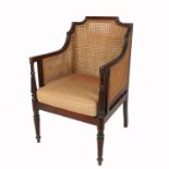 A Regency style mahogany framed bergere armchair, with reeded decoration to the arms and front