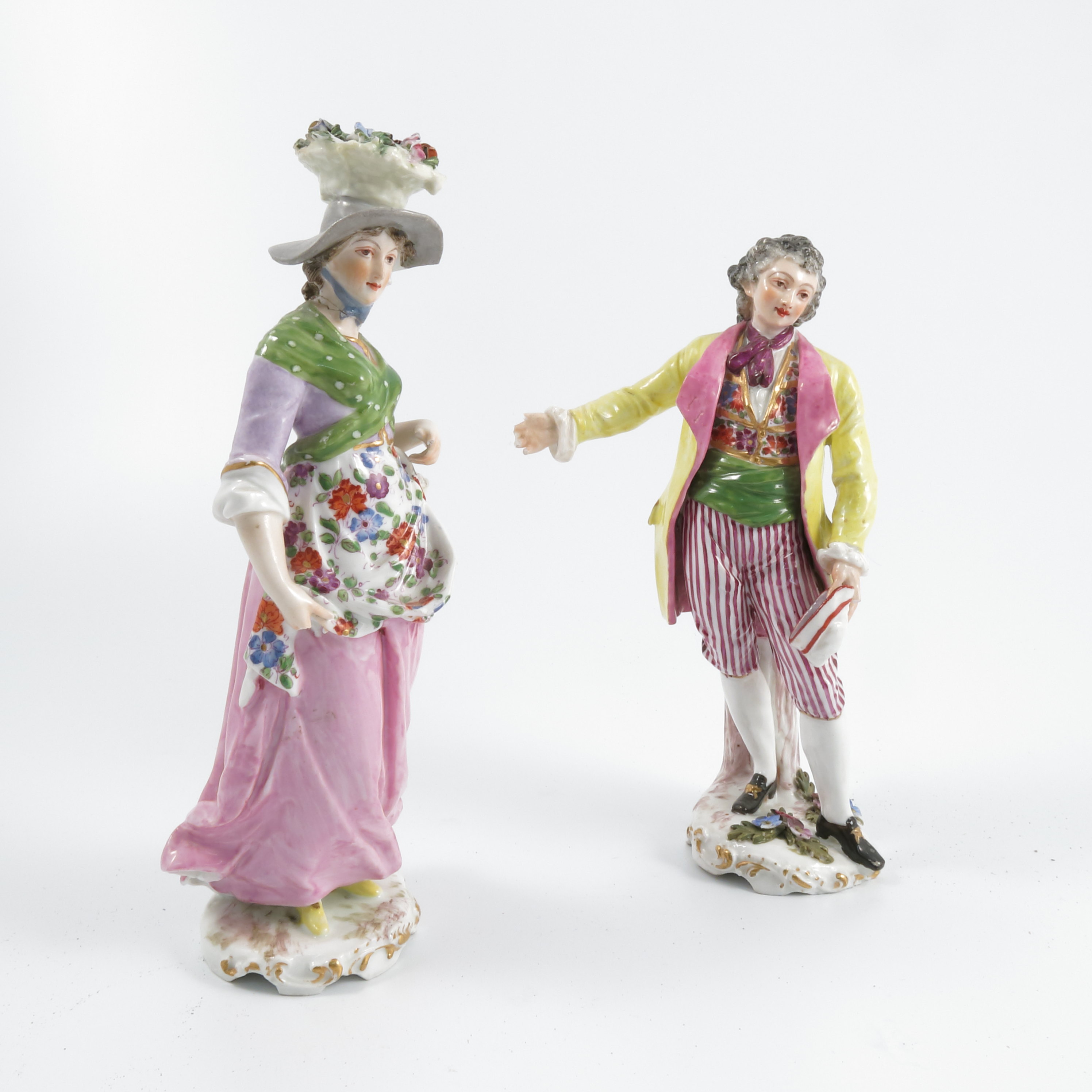 A pair of late 19th century continental porcelain figures, of a man wearing a yellow jacket and a