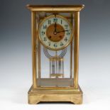 A gilt metal four glass mantel clock, the striking movement with white chapter ring, having a