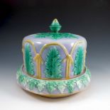 A 19th century majolica cheese dish and cover, of circular form, decorated with green leaves