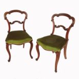 A pair of 19th century rosewood crown back chairs, with stuffover seats, raised on carved front