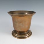 An Antique brass mortar, with flared rim, raised on a stepped circular foot, height 5ins