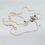 A string of seed pearls, the diamond set flower head clasp marked 18ct and Plat, together with
