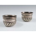 Two silver bowls, of circular form, with embossed decoration, both with inset shilling to the