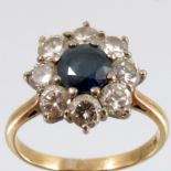 A sapphire and diamond cluster ring, stamped '18ct', the round cut sapphire of approximately 5.5mm