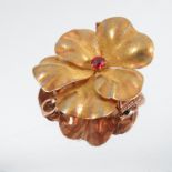 A Victorian gold flower brooch, set with a single garnet, having a hinged pendant loop, width 1.5ins