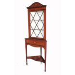 An Edwardian mahogany glazed corner cupboard, having astragal glazing bars raised on a stand, with