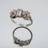 A diamond cluster ring, the white mount stamped 'P', the central baguette measuring approximately