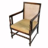 An oak framed bergere armchair, the cane sides missing