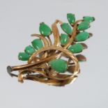 A jade spray brooch, unmarked, with twelve stone set 'leaves', 5cm long, 4.9g gross