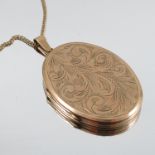 A large 9 carat gold oval locket, 4.3cm long excluding the bale, 17g gross, on a gilt metal chain
