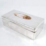 A hallmarked silver rectangular cigarette box, inset with an oval panel of two wading flamingos,