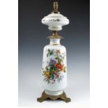 A 19th century milk glass lamp base, painted with flowers, having gilt metal mounts, the base with