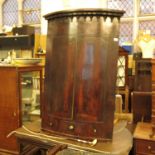 A 19th century mahogany barrel front corner cupboard, the pair of doors opening to reveal shelves,