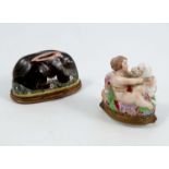 A 19th century relief moulded porcelain pill box, formed as a cherub and sheep, the sash to the