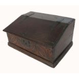 An antique oak bible box, with sloping rising lid, opening to reveal a shelf, and carved to the