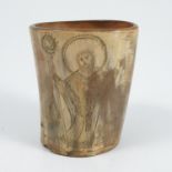 A 19th century carved horn beaker, decorated with various religious figures, having a wooden base,