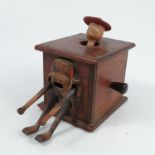 A wooden novelty box, with handle to the side that when turned makes the arms and legs of the figure