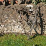 A wrought iron boot scraper. with twist handle. on a stone base, together with a wrought iron