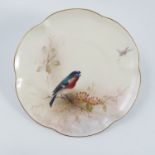 A Royal Worcester dessert plate, decorated with a Bullfinch and foliage by E Barker, with shaped