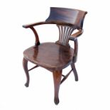 An Edwardian office armchair, with solid seat and cabriole front legs