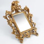A small gilt wood framed wall mirror, the very ornate frame formed of scrolling leaves, stamped Made