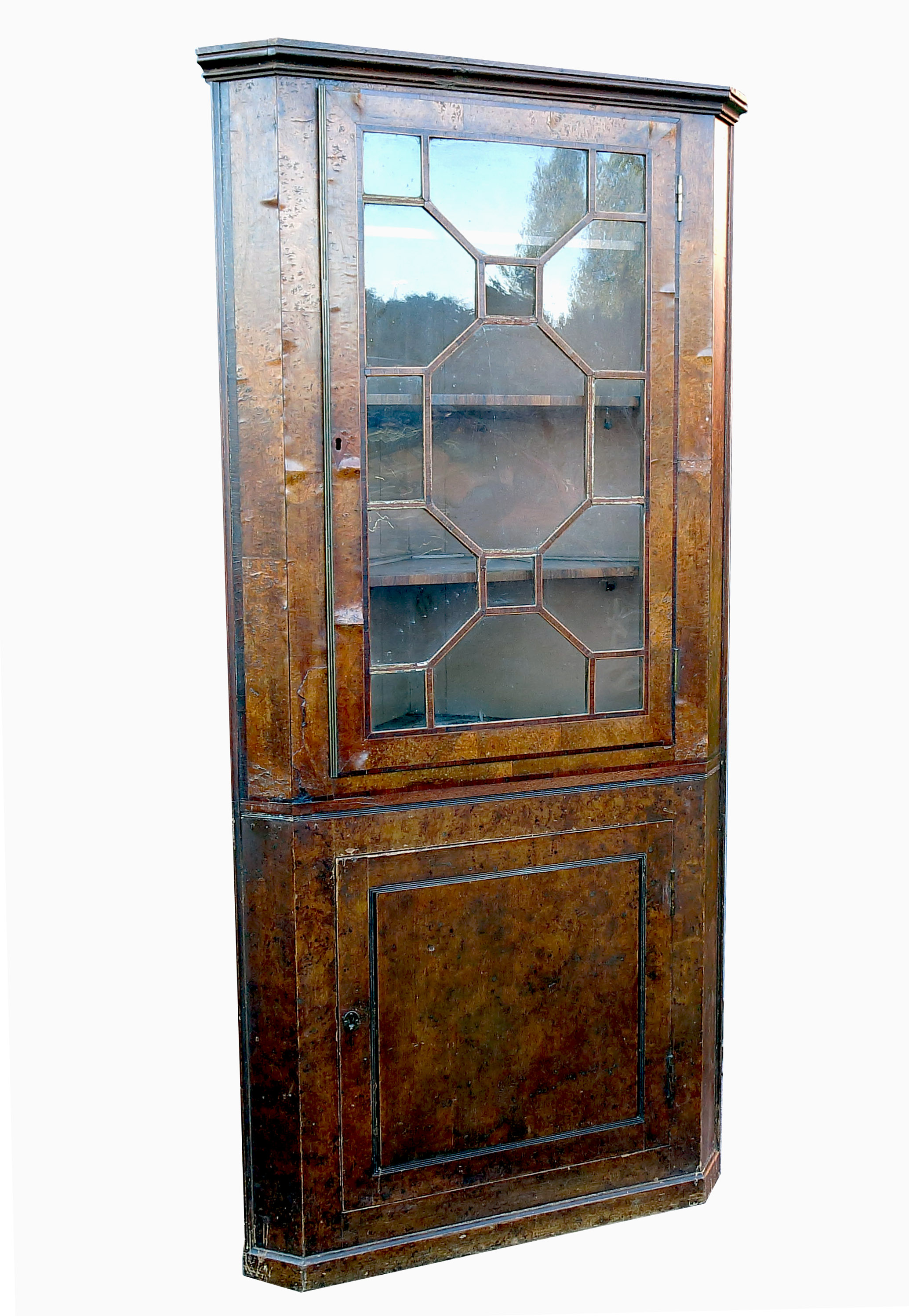 A burr wood free standing corner cupboard, with astragal glazed door, opening to reveal shelves,