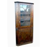 A burr wood free standing corner cupboard, with astragal glazed door, opening to reveal shelves,