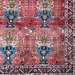 An Eastern style rug, decorated with repeated stylised flowers heads, animals and birds, 82ins x