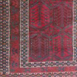 An Eastern design rug, decorated in red with a central field and three borders, 60ins x 41ins