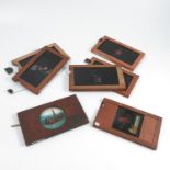 Seven mahogany framed magic lantern slides, each hand coloured and with moving glass panel,
